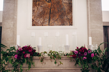 Fireplace decorated with flowers of asters and dahlias and candles