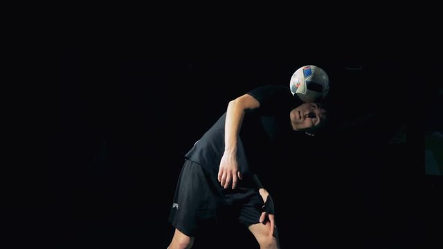 Young professional soccer football player juggles a ball.