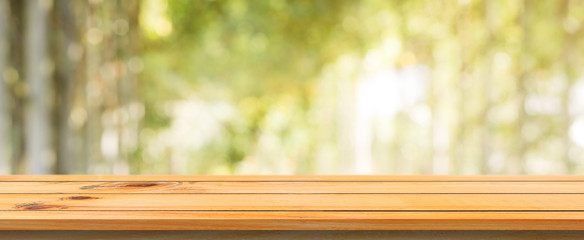 Wooden board empty table blurred background. Perspective brown wood table over blur trees forest background - can be used mock up for display or montage your products. spring season. panoramic banner.
