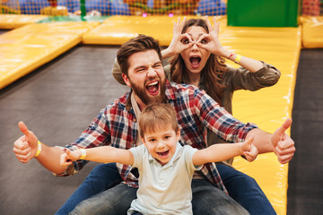 Funny young family with their little son spending time