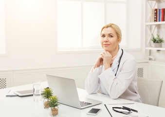 Portrait of female doctor sitting at the desktop