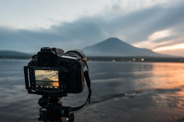 夕方の山中湖にて富士山を撮影中の一眼レフカメラ