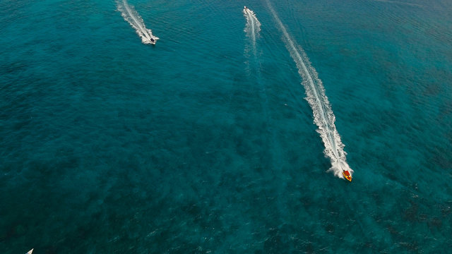 Aerial view of speed boat in sea, Boracay. Speed boat at sea, view from above. Speedboat floating in a turquoise blue sea water. Motorboat crossing ocean. Tropical landscape. Philippines