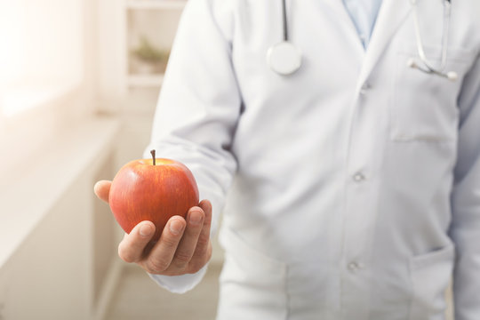Apple in doctor's hand closeup