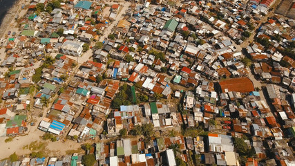Fototapeta na wymiar Aerial view poor district of Manila slums, ghettos, wooden old houses, shacks. Slum area of Manila, Philippines. Manila suburb, view from the plane.
