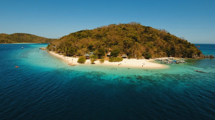 Aerial view of tropical beach on the island Banana, Philippines. Beautiful tropical island with sand beach, palm trees. Tropical landscape: beach with palm trees. Seascape: Ocean, sky, sea. Travel