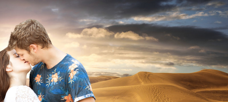 giovane coppia che di bacia tra le dune del deserto