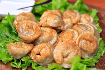 Fried pelmeni on a wooden board
