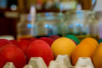 Close-up of eggs during dyeing. Fresh spring colors and jars with paint. Shallow depth of focus. Concept Easter.