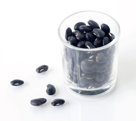 Dried black beans in small glass with white background. selective focus image.
