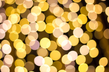 Blurred photo of yellow bokeh background of defocused glittering lights