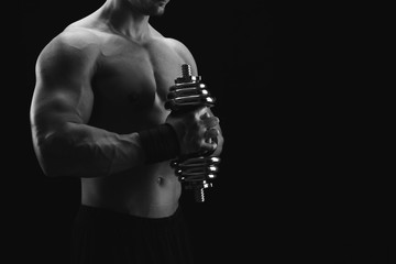 Strong athletic man with dumbbell showes naked muscular body