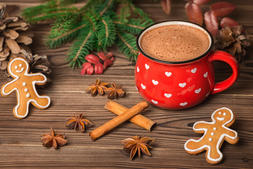 hot chocolate or cocoa, gingerbread cookies decorated, Christmas tree branch, cones, cinnamon and anis on wooden background, greeting card