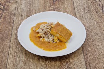 Tofu and pumpkin sauce with pasta on a table