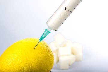 the syringe with the sugar in the lemon