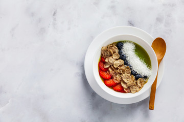 two bowls with different Smoothies from strawberries and kiwi, with Cereals for a healthy Breakfast and berries, chia seeds and coconut chips . Wheat bran and Cornflake. super food