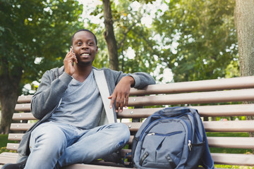 Smiling african-american student talking on the phone outdoors