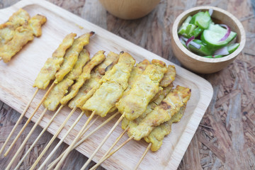 Pork satay on skewers on wood tray