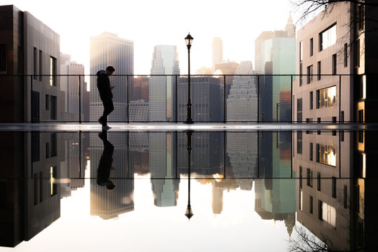 Reflection of man and cityscape in water
