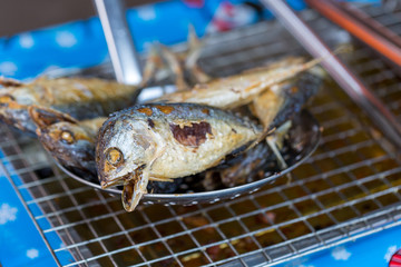 Fried mackerel fish put on the grill to drain oil.