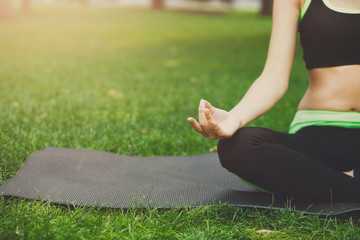 Woman training yoga in lotus pose, closeup