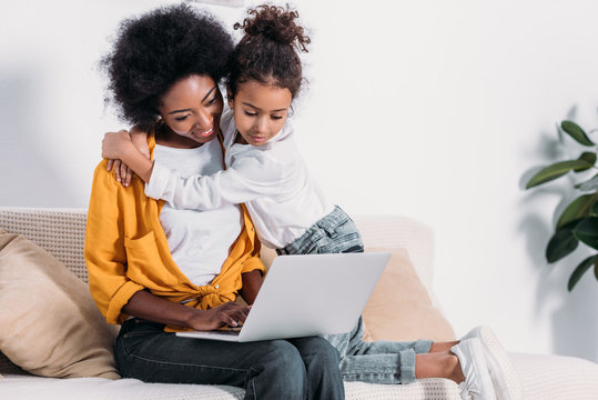 African American Mother And Daughter Watching Something On Laptop At Home