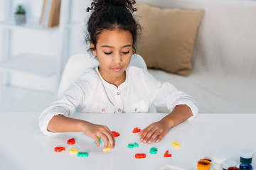 adorable african american kid learning colored numbers at home