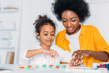 african american mother teaching daughter numbers at home