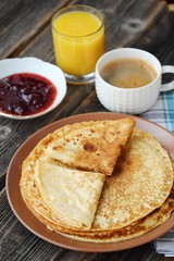 Fresh pancakes with strawberry jam, coffee and juice 