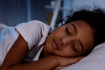 adorable african american kid sleeping in bed at home - Powered by Adobe
