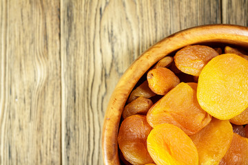 Dried apricots, dried fruits in a wooden plate. Rustic style. Healthy diet. Place for text.