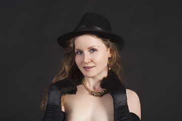 Portrait of a young woman in a hat and gloves.