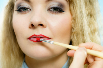 Applying lipstick on fashion model lips