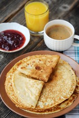 Fresh pancakes with strawberry jam, coffee and juice 