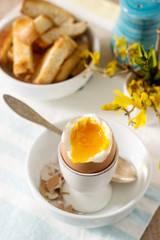 Breakfast from soft-boiled egg, bread toast, coffee with cream and fresh newspaper.
