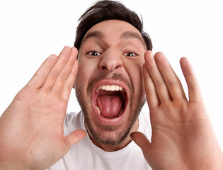 Handsome bearded funny man is yelling with his mouth opened wide is isolated on a white background...