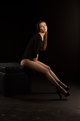 Attractive brunette woman with long legs posing in the shadow