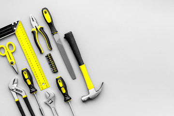 Repair tools. File, hummer, corner ruler, pilers on grey background top view copy space pattern