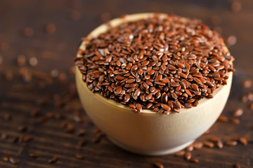 Close up linseed in wooden bowl on wooden table