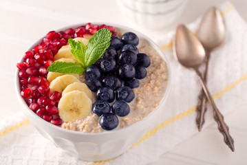 Steel Cut Oats with Pomegranage Seed, Banana, and Blueberries with a Sprig of Mint