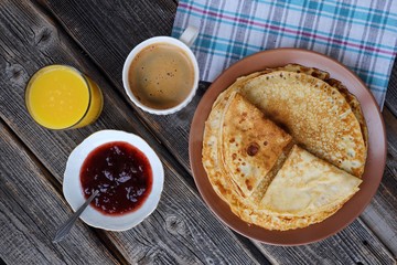 Fresh pancakes with strawberry jam, coffee and juice 