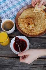 Fresh pancakes with strawberry jam, coffee and juice 