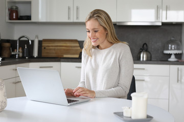 Hübsche blonde Frau mit Laptop lacht