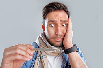 Handsome bearded man is sick isolated on a white background. Sad concerned guy in a scarf is ill...