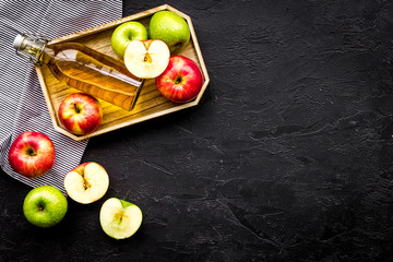 Bottle of fresh cider near autumn apples. Black background top view space for text