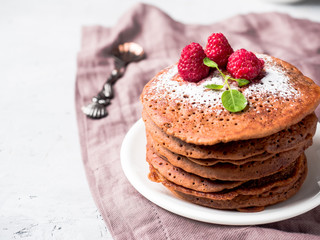 Chocolate pancakes with powdered sugar raspberry