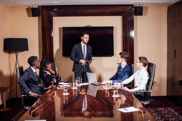 Business executive delivering presentation to colleagues during meeting or business training, explaining business plans to employees.