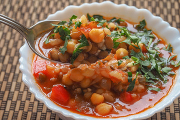Moroccan soup harira with meat chickpeas lentil tomato lemon and spices in bowl. Arabic food.
