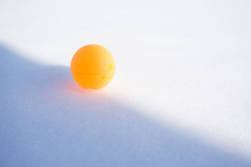 Ping pong ball on the snow. Table tennis, also known as ping pong, is a sport in which two or four players hit a lightweight ball back and forth across a table using small bats