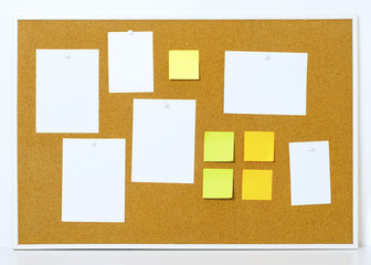 Items pinned to a cork message board with wood frame, for customized text or images. Yellow stick notes.